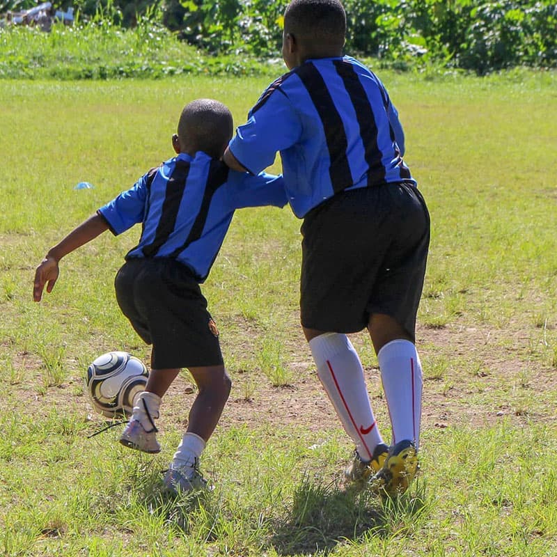 Two players going for the ball on the Bath Estate playing field